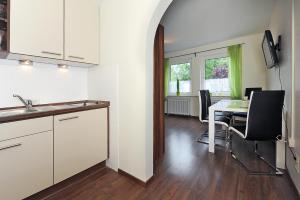 a kitchen and dining room with a table and chairs at Haus Hafenromantik in Neuharlingersiel