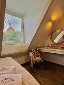 ein Schlafzimmer mit einem Fenster, einem Spiegel und einem Stuhl in der Unterkunft LTS RENT Luxury&Comfortable Etno Loft OLD TOWN free parking in Danzig