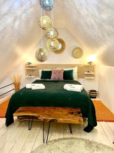 ein Schlafzimmer mit einem Bett mit einer grünen Bettdecke in der Unterkunft LTS RENT Luxury&Comfortable Etno Loft OLD TOWN free parking in Danzig