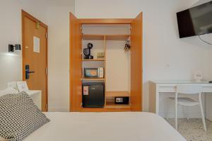 a bedroom with a bed and a desk and a computer at Hotel y Apartamento Moli de Mar - Check-in 24 Horas in Lloret de Mar