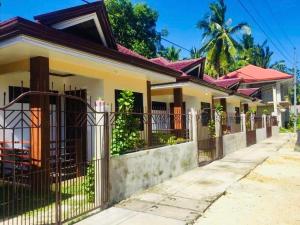 a house with a fence in front of it at Ameeza Houze Homestay - Siargao in General Luna