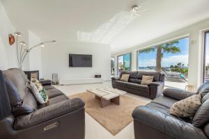 ein Wohnzimmer mit 2 Ledersofas und einem Tisch in der Unterkunft Villa Catalina by Algarve Vacation in Armação de Pêra