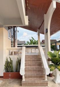 a staircase leading up to a house with a wooden ceiling at 97 Light House Songkhla in Songkhla