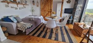 a living room with a couch and a table and chairs at Casa Mar do Triângulo in Horta