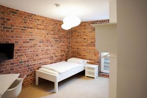 ein Zimmer mit einer Backsteinwand und einem Bett darin in der Unterkunft urraum Hotel in Pulheim