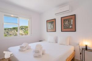 a white bedroom with a bed with towels on it at CostaBlancaDreams Casa Tinick in Calpe in Empedrola +49 photos
