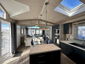 a kitchen and living room with a large window at Lodge No 20 - Stewart's Resort Cameron in St. Andrews