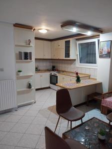a kitchen with white cabinets and a table and chairs at Ntolos House Old Town in Kavála