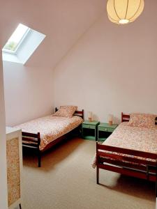 a bedroom with two beds and a window at La Garencière - Les 3 pommes in Champfleur