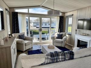 a living room with a couch and a fireplace at Lodge No 20 - Stewart's Resort Cameron in St. Andrews