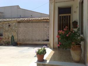 a house with two potted plants in front of a door at Casa vacanze Franci in Custonaci