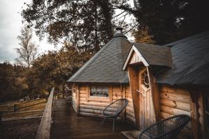 eine Hütte mit zwei Stühlen auf einer Holzterrasse in der Unterkunft Le Kota Montagne in Les Poulières