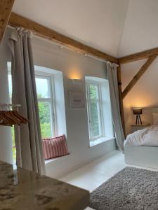 a bedroom with two windows and a bed and a table at Schumis Ferienhus in Garding