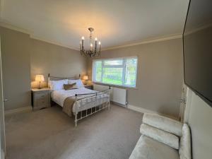 a bedroom with a bed and a window and a chandelier at Ballyness Lodge in Derry Londonderry +12 photos