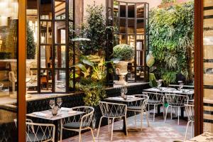 a restaurant with tables and chairs and plants at Roma Luxus Hotel in Rome