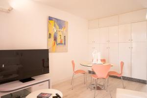 Una sala de estar con una mesa y sillas y un televisor. en Casa Alejandro WIFI & POOL & 24H SECURITY, en Arona 9 fotos más