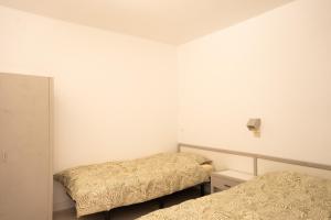 Dos camas en una habitación con paredes blancas. en Casa Alejandro WIFI & POOL & 24H SECURITY, en Arona