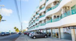 若昂佩索阿Manaira Flat的街道旁的一座大型建筑,有汽车停放