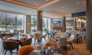 リバプールにあるMaldron Hotel Liverpool City Centreのテーブルと椅子と窓のあるレストラン