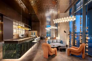 a lobby with a couch and a table and chairs at The Perennial Tianjin, A Jdv By Hyatt Hotel in Tianjin