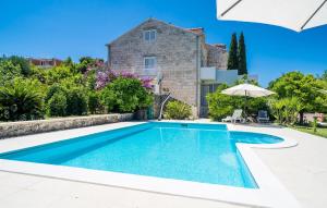 a villa with a swimming pool in front of a house at Cozy Apartment In Zaton Veliki in Zaton +20 photos