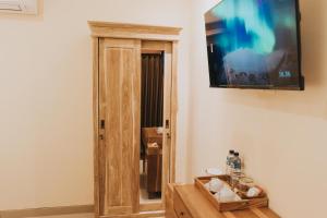 a television hanging on a wall next to a door at Aruna House in Ubud