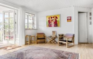 un soggiorno con pareti bianche, tavolo e sedie di Nice Home In Gilleleje With Wifi a Gilleleje