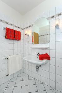 a white bathroom with a sink and a mirror at Haus Hafenromantik in Neuharlingersiel