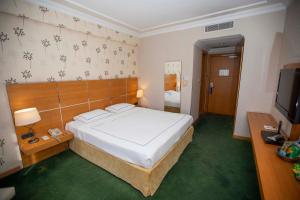 A bed or beds in a room at Anemon Grand Manisa Otel