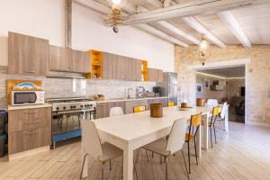 Una cocina con una mesa y sillas en una habitación. en Villa Antica Aia Relax, en Scicli