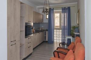 a kitchen with wooden cabinets and orange chairs in it at Il sospiro B&B in Spinoso
