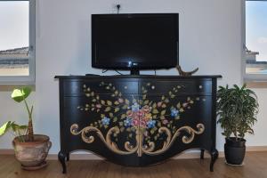 a black dresser with a television on top of it at Il sospiro B&B in Spinoso
