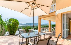 un patio con tavolo, sedie e ombrellone di Villa Carmela a Baena