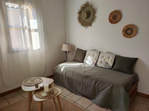 ein Schlafzimmer mit einem Bett, zwei Tischen und einem Fenster in der Unterkunft Le Mas de la Rode in Saumane