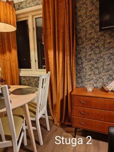 a dining room with a table and chairs and a window at Stuga utanför Skövde 2 in Skövde