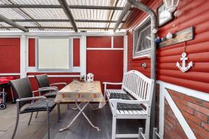 un patio con mesa y sillas en una pared roja en Ferienhaus Wallenstein, en Kappeln