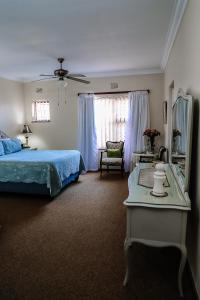 a bedroom with a bed and a mirror and a table at Die C Skulp in Hartenbos
