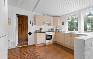 a kitchen with white cabinets and a stove top oven at 3 Bedroom Stunning Home In Skjern in Skjern