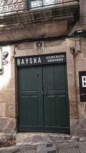 zielone drzwi na budynku z znakiem powyżej w obiekcie Acio Tinto Loft Casco Histórico de Ourense w mieście Ourense