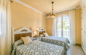 una camera da letto con due letti e una finestra di Villa Carmela a Baena Altre 21 foto