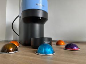 メストレにあるAt Home Mestre Via Nigra Venezia come a casa ma in vacanzaのテーブルの上に5つの異なる色のヘルメットが置かれたコーヒーメーカー