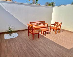 two benches and a table on a patio at Casa do Lago da Dinda 2 in Espirito Santo Do Pinhal