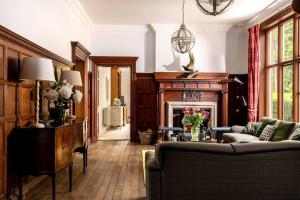 ein Wohnzimmer mit Sofa und Kamin in der Unterkunft Gresham Hall - Norfolk Cottage Agency in Norwich