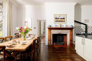 ein Esszimmer mit Tisch und Kamin in der Unterkunft Gresham Hall - Norfolk Cottage Agency in Norwich