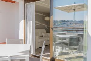 a room with a balcony with a table and chairs at MUPA Apartments in Albufeira