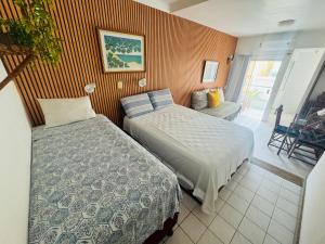 Un dormitorio con dos camas y una sala de estar. en Flat encantador beira mar na Barra . Em frente a praia! No Circuito do Carnaval de Salvador!, en Salvador 25 fotos más