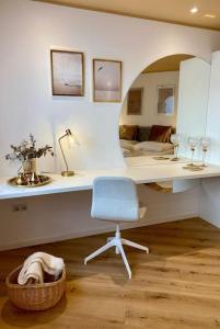 a room with a desk with a chair and a mirror at Komfort - Suite zentral, mit Balkon und Waschmaschine in Düsseldorf