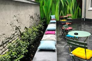 a row of pillows on a patio with tables and chairs at Komfort - Suite zentral, mit Balkon und Waschmaschine in Düsseldorf