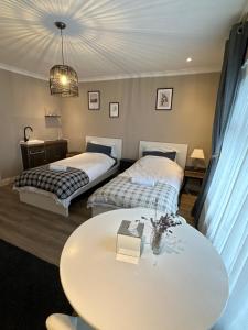 two beds in a room with a table and a table sidx sidx sidx at Park Terrace Family Room in Glastonbury