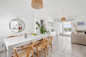 a white dining room with a white table and chairs at Ivy Blue Villa by Nomads - Short Walk to Coral Bay in Peyia